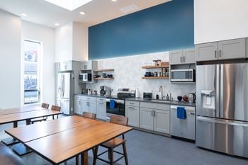 A modern kitchen with a wooden table and stainless steel appliances.